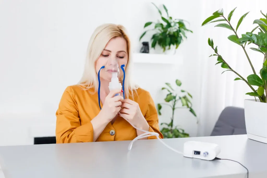 A lady breathing with the help of oxygen mask. 